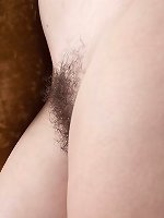 Liana poses naked on her beige sofa